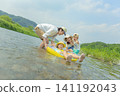 A family of four playing in the river in summer. 141192043