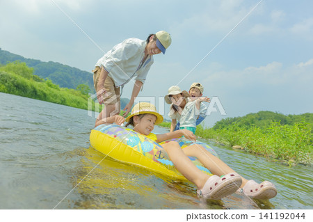 夏天,一家四口在河裡玩耍。 夏天,一家四口在河裡玩耍。 141192044