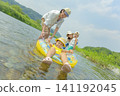 A family of four playing in the river in summer. 141192045