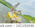 A family of four playing in the river in summer. 141192046