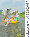 A family of four playing in the river in summer. 141192047