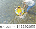A girl and her mother playing in a river in summer 141192055
