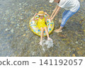 A girl and her mother playing in a river in summer 141192057