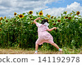A girl looking happy in a sunflower field 141192978