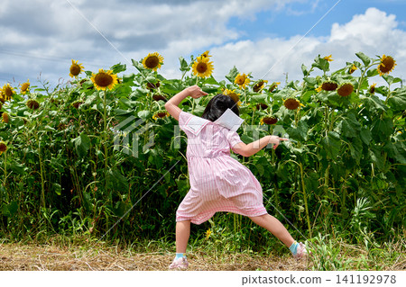 A girl looking happy in a sunflower field A girl looking happy in a sunflower field 141192978