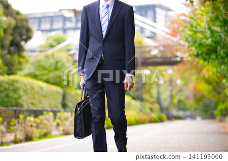 一位二十多歲的商人正在戶外散步。 一位二十多歲的商人正在戶外散步。 141193000