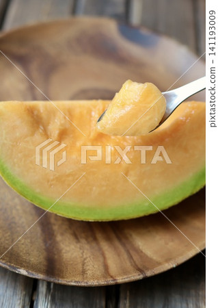 A perfectly ripe, sweet, and delicious Yubari melon, served with chopsticks. (Red-fleshed melon) A perfectly ripe, sweet, and delicious Yubari melon, served with chopsticks. (Red-fleshed melon) 141193009