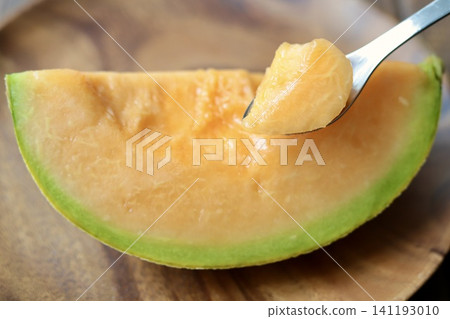 A perfectly ripe, sweet, and delicious Yubari melon, served with chopsticks. (Red-fleshed melon) A perfectly ripe, sweet, and delicious Yubari melon, served with chopsticks. (Red-fleshed melon) 141193010