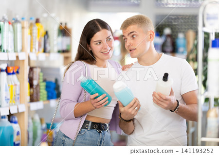 Young couple choosing shampoo and shower gel in department store Young couple choosing shampoo and shower gel in department store 141193252