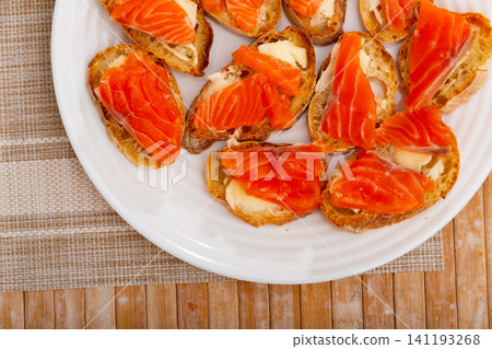 Sliced baguette with butter and smoked salmon fillet Sliced baguette with butter and smoked salmon fillet 141193268