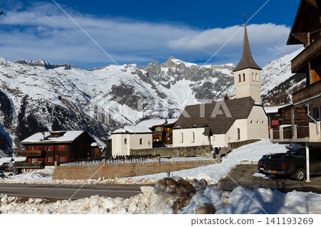 Winter view of Swiss township of Bellwald with parish church 141193269