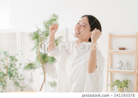 一位三十多歲的女性在客廳裡十分開心。 141193378