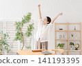 一位三十多歲的女性在客廳裡十分開心。 141193395