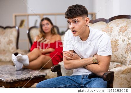 Unhappy woman quarrelling with husband at home interior Unhappy woman quarrelling with husband at home interior 141193628