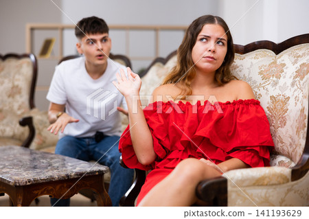 Disgruntled young husband swears at his wife Disgruntled young husband swears at his wife 141193629