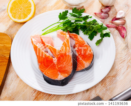 Uncooked salmon steaks on plate Uncooked salmon steaks on plate 141193636