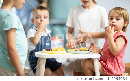 Children sitting at the table and eating 141193684