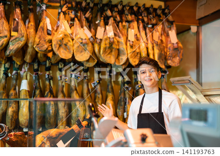 Jamon market worker gesturing and looking at camera 141193763