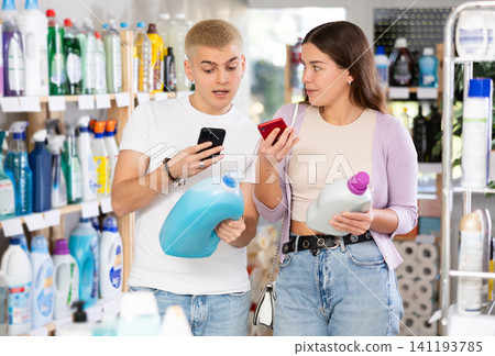Young couple scanning QR-code on detergent in department store Young couple scanning QR-code on detergent in department store 141193785