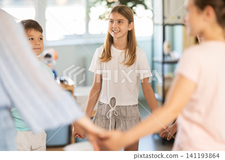 Children holding hands in circle dance with teacher Children holding hands in circle dance with teacher 141193864