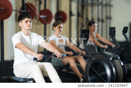 Young guy trains his arms on machine Young guy trains his arms on machine 141193947