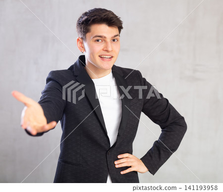 Smiling surprised young male student in suit jacket pointing at you.Portrait of guy pointing finger Smiling surprised young male student in suit jacket pointing at you.Portrait of guy pointing finger 141193958