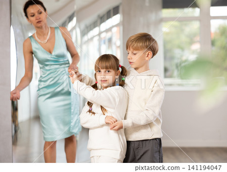 Boy with girl dressed in sport wear train to dance waltz during classes. Boy with girl dressed in sport wear train to dance waltz during classes. 141194047