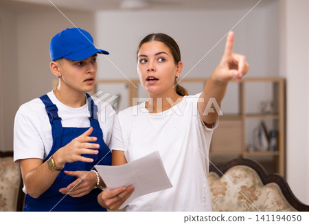 Landlady of an apartment explains to a young worker the plan of repair work Landlady of an apartment explains to a young worker the plan of repair work 141194050