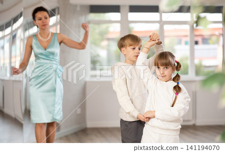 Preteen ballroom dancers practicing elegant dance in pair in studio Preteen ballroom dancers practicing elegant dance in pair in studio 141194070