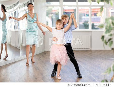 Tween girl and boy rehearsing rumba as couple in dance studio Tween girl and boy rehearsing rumba as couple in dance studio 141194112