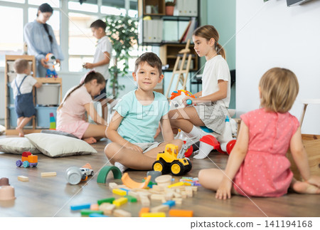 Group of children playing with various toys in kindergarten Group of children playing with various toys in kindergarten 141194168