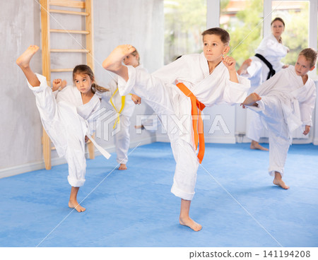 Children students repeat position and perform sequence of punches and painful techniques kata Children students repeat position and perform sequence of punches and painful techniques kata 141194208