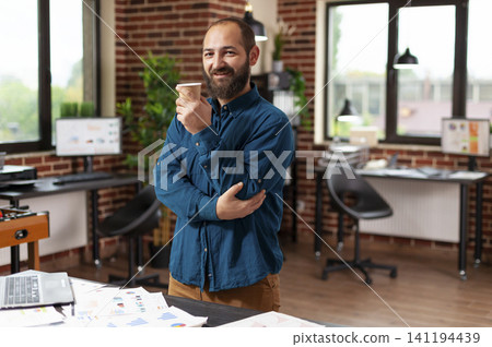 Diverse colleagues plan business presentation at startup desk while businessman cup, cup coffee and coffee startup shape the situation in a office setting Diverse colleagues plan business presentation at startup desk while businessman cup, cup coffee and coffee startup shape the situation in a office setting 141194439