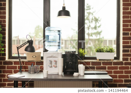 Water dispenser and coffee machine stand on a meeting office table, offering fresh beverages and hydration during workplace breaks. Water dispenser and coffee machine stand on a meeting office table, offering fresh beverages and hydration during workplace breaks. 141194464