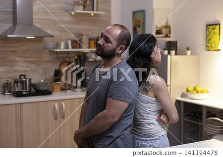 Angry married couple argues at home about jealousy, infidelity and relationship trouble, with frustration and conflict visible between partners as part of a natural family lifestyle moment involving. Angry married couple argues at home about jealousy, infidelity and relationship trouble, with frustration and conflict visible between partners as part of a natural family lifestyle moment involving. 141194478