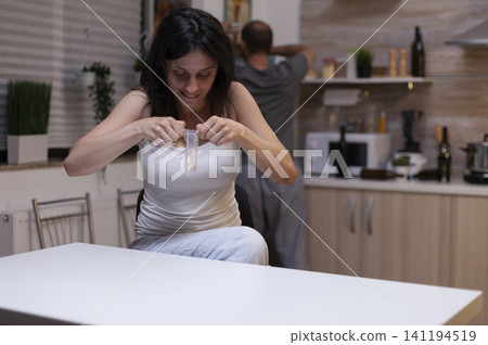 Desperate person holds a small bag of white powder drugs, suggesting cocaine or heroin dependency, illegal substance abuse and overdose danger. Desperate person holds a small bag of white powder drugs, suggesting cocaine or heroin dependency, illegal substance abuse and overdose danger. 141194519