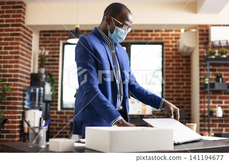 Businessman closes laptop after office task, combining workplace safety, laptop work and professional productivity during a focused workplace task. 141194677