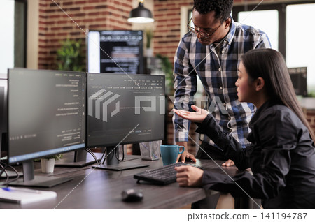 Diverse team of system engineers developing html code and cloud computing in it development agency, Asian software developer typing on keyboard to create artificial intelligence script. Diverse team of system engineers developing html code and cloud computing in it development agency, Asian software developer typing on keyboard to create artificial intelligence script. 141194787