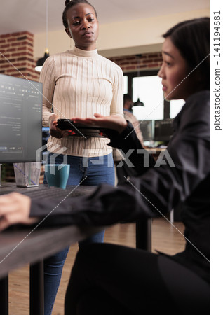 Software development team reviewing HTML code together in a programming workspace, connecting source code, database logic and collaborative development for a technology project. 141194881