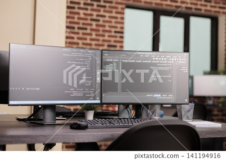 Empty IT office desk shows computer monitors running terminal windows, artificial intelligence database scripts and server cloud computing code in a software workspace. Empty IT office desk shows computer monitors running terminal windows, artificial intelligence database scripts and server cloud computing code in a software workspace. 141194916