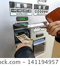 Insert a 10,000 yen bill into the exchange machine 141194957