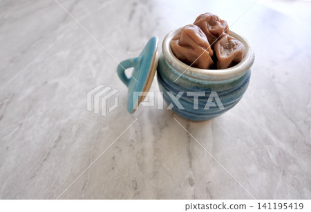 Homemade pickled plums in a storage container and copy space Homemade pickled plums in a storage container and copy space 141195419