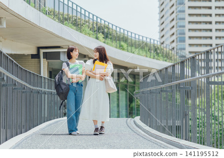Two female university students walking on the university campus Two female university students walking on the university campus 141195512