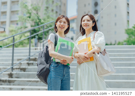 Two female university students walking on the university campus Two female university students walking on the university campus 141195527