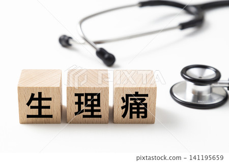 一塊標示「經痛」的積木和一個聽診器。 一塊標示「經痛」的積木和一個聽診器。 141195659