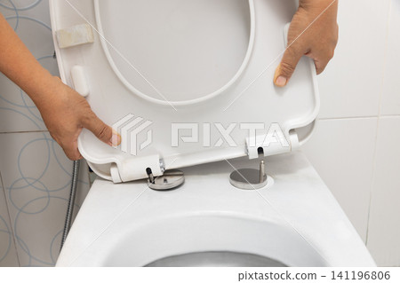 Worker replace hinge rubber plug and Screws for Toilet Seat Worker replace hinge rubber plug and Screws for Toilet Seat 141196806
