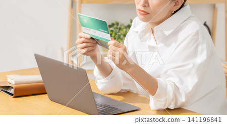 A woman troubled with her bankbook A woman troubled with her bankbook 141196841