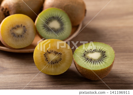 Fresh green and gold kiwi fruit on wooden background. Healthy eating Fresh green and gold kiwi fruit on wooden background. Healthy eating 141196911