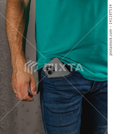 Man shows smartphone in pocket of jeans while standing and dressed casually Man shows smartphone in pocket of jeans while standing and dressed casually 141197514