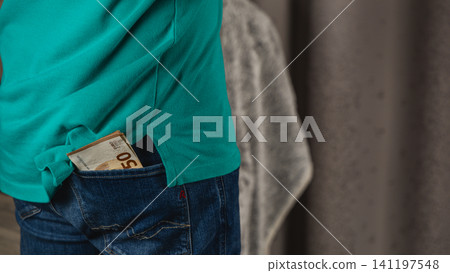 Man stands with euro notes in back pocket of jeans 141197548